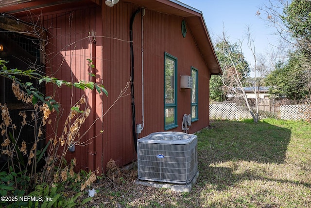 view of home's exterior with central AC and a lawn