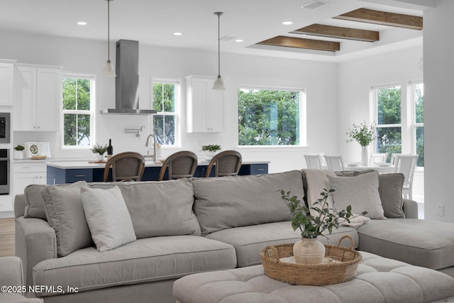 living room with beam ceiling, wood finished floors, and recessed lighting