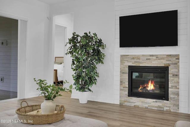 living room featuring wood finished floors and a glass covered fireplace