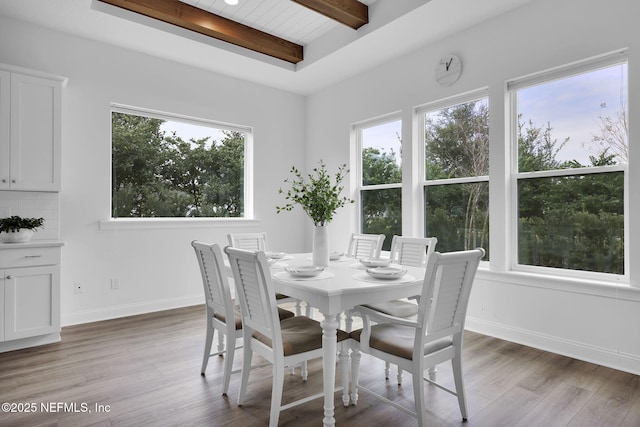 dining area featuring dark wood-style floors, baseboards, and beam ceiling