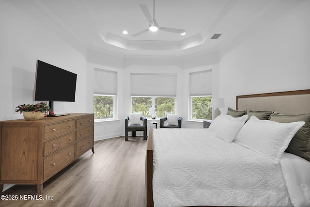 bedroom with visible vents, ornamental molding, a tray ceiling, light wood-style floors, and recessed lighting