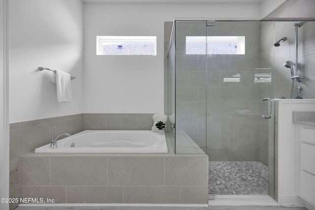 bathroom with a shower stall and a bath