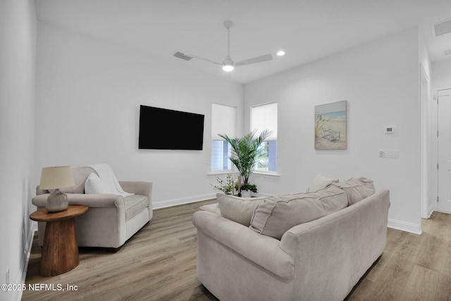 living room featuring light wood-style floors, baseboards, visible vents, and ceiling fan