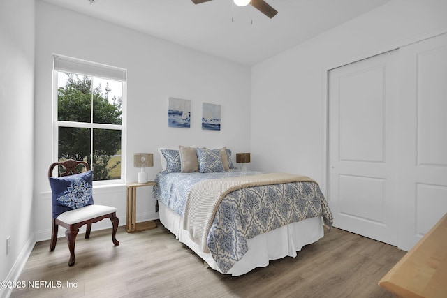 bedroom with wood finished floors, a ceiling fan, and baseboards