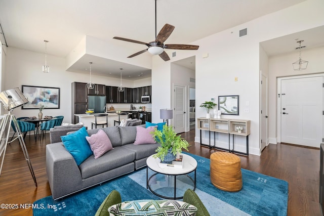 living room with dark wood-type flooring and ceiling fan