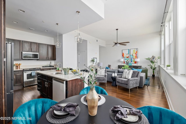 kitchen featuring appliances with stainless steel finishes, sink, a center island with sink, and dark brown cabinetry