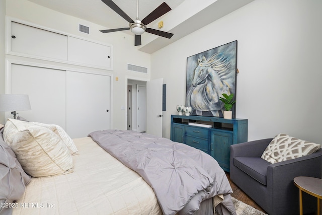 bedroom featuring a high ceiling, ceiling fan, and a closet