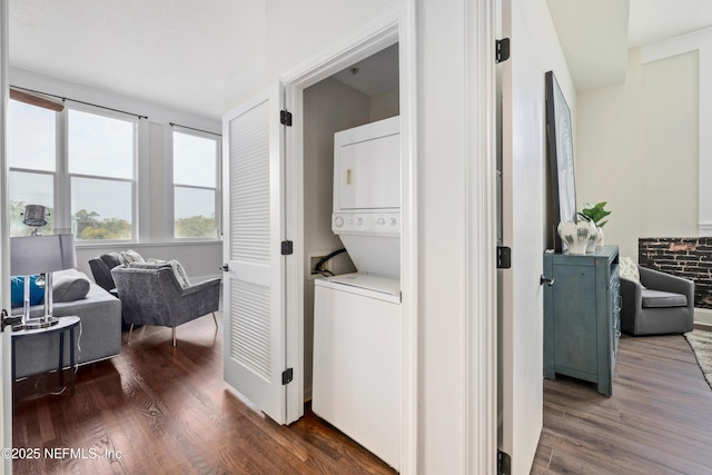 washroom with stacked washer and dryer and dark hardwood / wood-style flooring