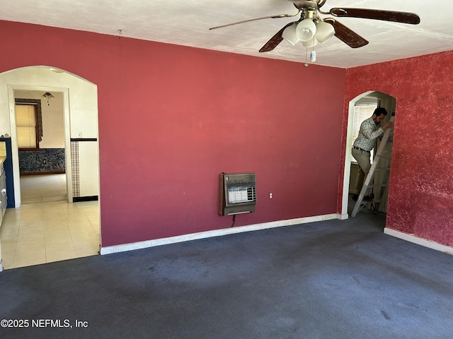 empty room with ceiling fan, carpet flooring, and heating unit