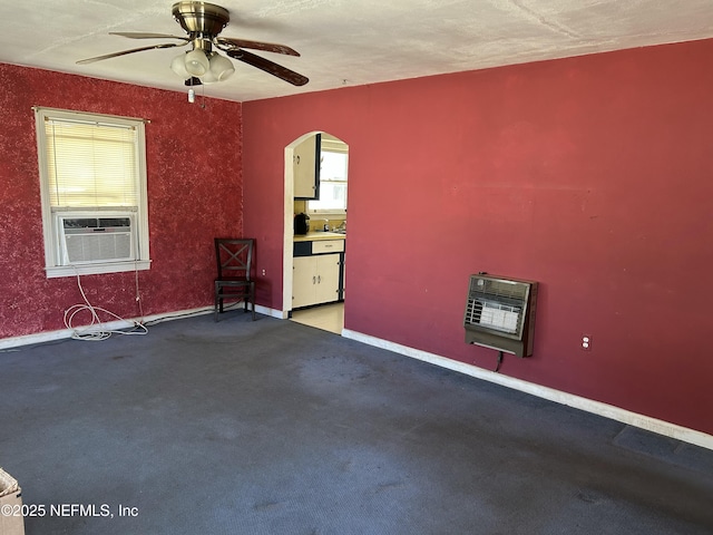 spare room featuring heating unit, cooling unit, carpet floors, and ceiling fan