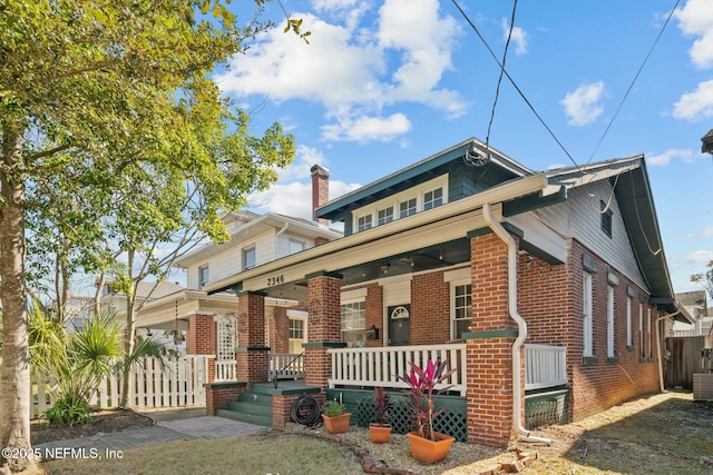 bungalow-style home with covered porch and central air condition unit