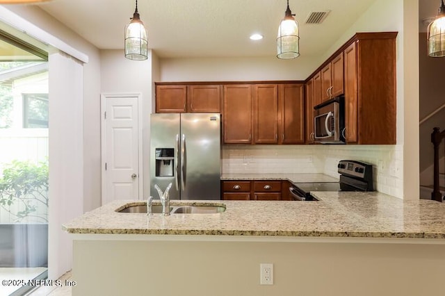 kitchen featuring stainless steel appliances, decorative light fixtures, light stone countertops, and kitchen peninsula