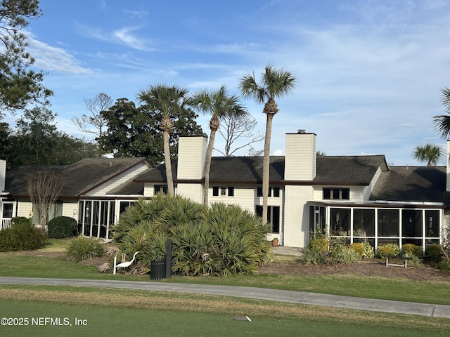 view of front of house featuring a sunroom and a front yard