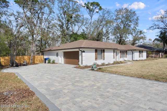 ranch-style house featuring a garage and a front yard