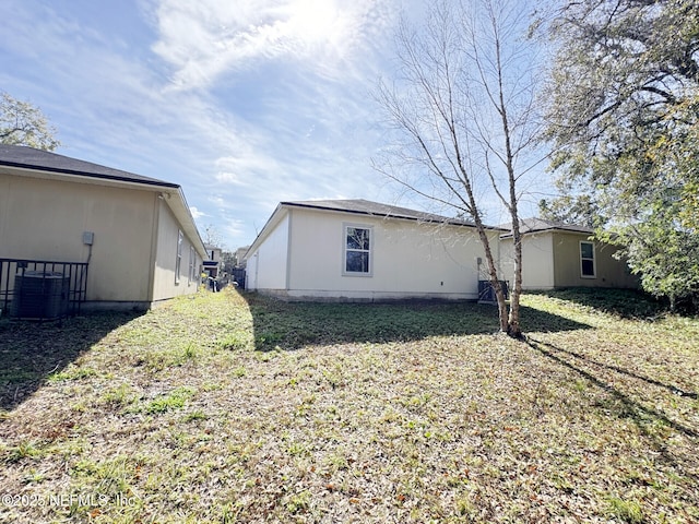 rear view of house featuring a yard and cooling unit