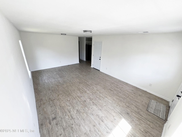 unfurnished room with wood-type flooring