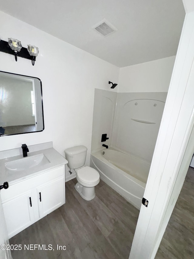 full bathroom with wood-type flooring, toilet, vanity, and shower / bathing tub combination