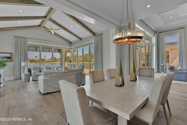 dining room featuring an inviting chandelier, a water view, light wood finished floors, baseboards, and beam ceiling