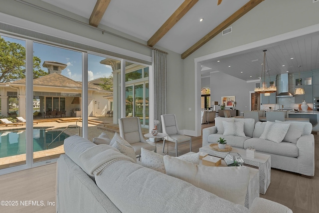 living area featuring light wood-type flooring, visible vents, recessed lighting, baseboards, and beam ceiling