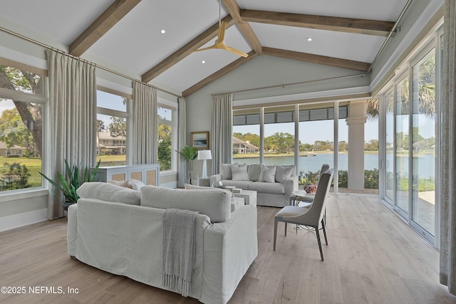 sunroom / solarium featuring a water view, beamed ceiling, and wood finished floors
