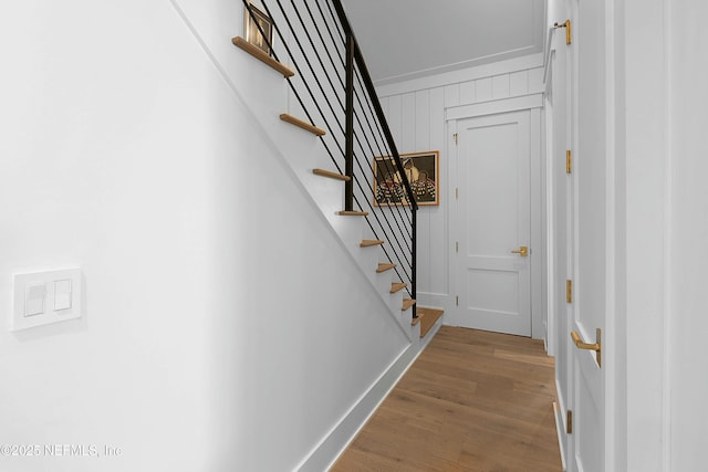 interior space with wood finished floors, baseboards, and stairway