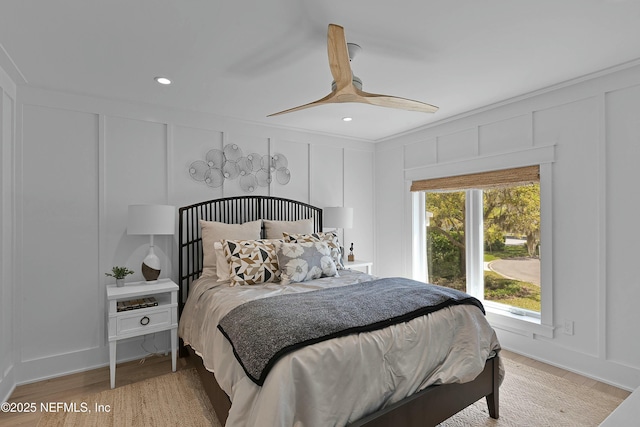 bedroom featuring recessed lighting, a decorative wall, light wood finished floors, and a ceiling fan
