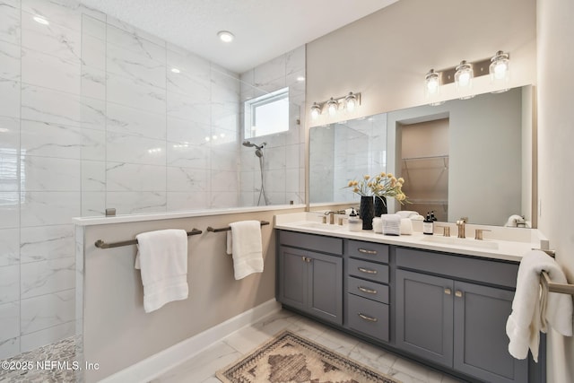 bathroom with a walk in shower, marble finish floor, and a sink