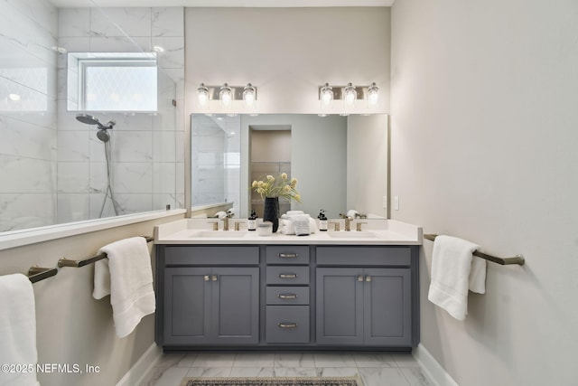 full bath featuring double vanity, marble finish floor, walk in shower, and a sink