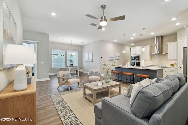 living area with light wood finished floors, visible vents, baseboards, ceiling fan, and recessed lighting