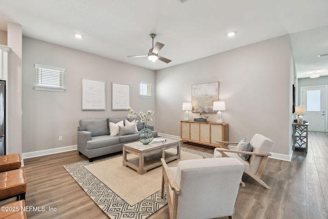 living room with a wealth of natural light, baseboards, a ceiling fan, and wood finished floors