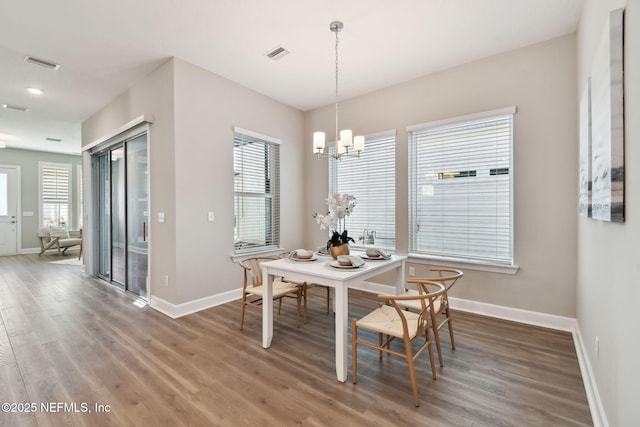 dining space featuring wood finished floors, visible vents, and a healthy amount of sunlight