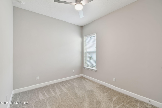 spare room with carpet flooring, baseboards, and a ceiling fan