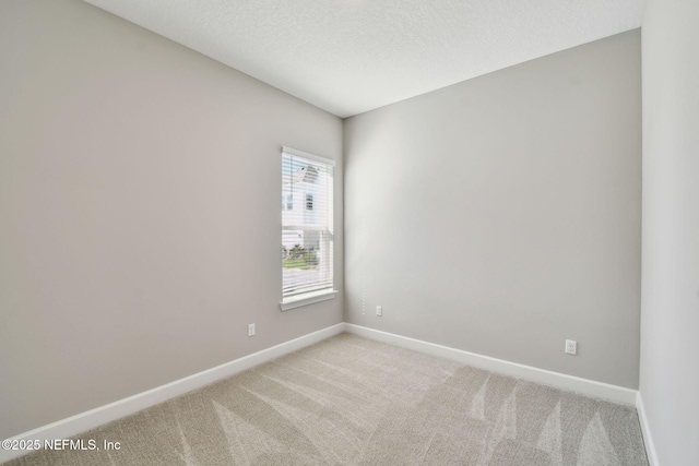 unfurnished room featuring a textured ceiling, baseboards, and light carpet