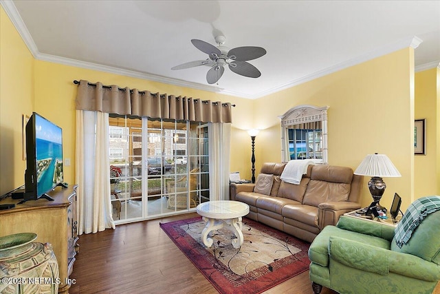 living area with ornamental molding, a ceiling fan, and wood finished floors