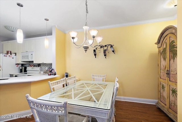 dining space featuring a notable chandelier, dark wood-type flooring, baseboards, and crown molding