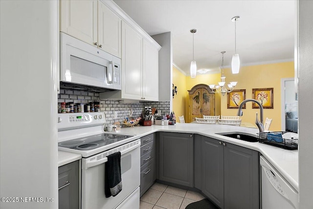 kitchen featuring white appliances, crown molding, a sink, and gray cabinetry