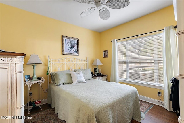 bedroom with a ceiling fan, baseboards, and wood finished floors