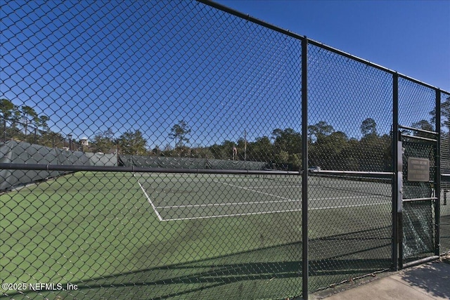 view of tennis court featuring fence