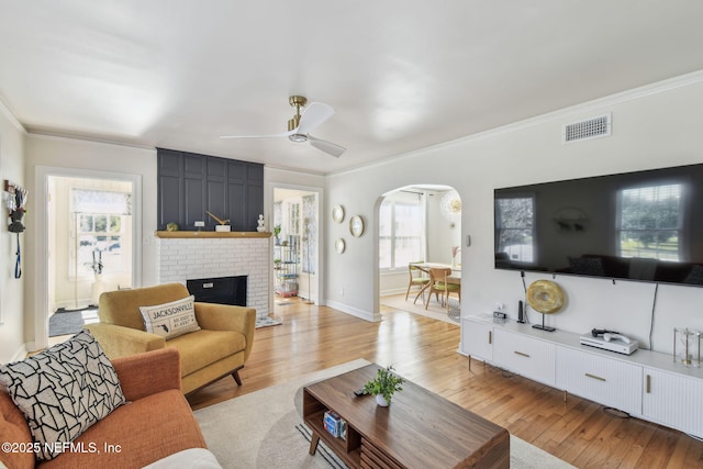 758 Acosta St, Jacksonville, FL 32204 - living room featuring crown molding, a fireplace, ceiling fan, and light wood-type flooring