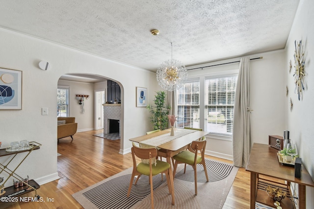 758 Acosta St, Jacksonville, FL 32204 - dining space featuring a fireplace, light hardwood / wood-style flooring, and a textured ceiling