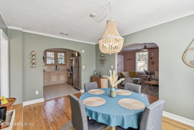 758 Acosta St, Jacksonville, FL 32204 - dining area featuring an inviting chandelier, light hardwood / wood-style flooring, ornamental molding, and a textured ceiling