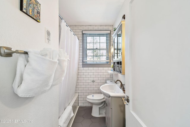 758 Acosta St, Jacksonville, FL 32204 - full bathroom featuring tile patterned floors, toilet, shower / tub combo, tile walls, and vanity