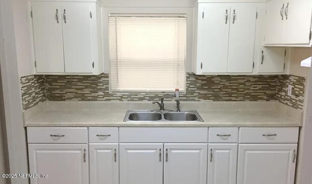 kitchen featuring white cabinetry, light countertops, and a sink