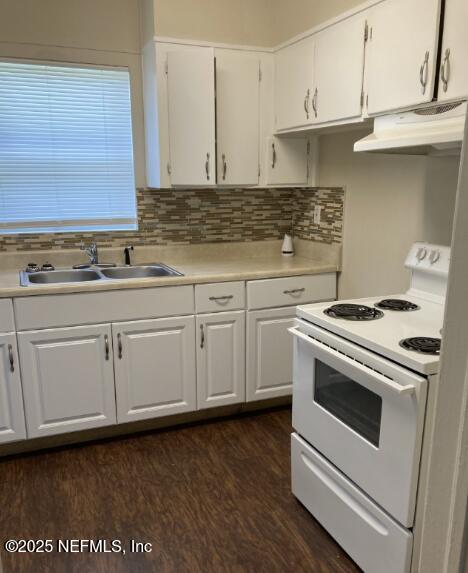 kitchen featuring white range with electric stovetop, light countertops, white cabinetry, a sink, and under cabinet range hood