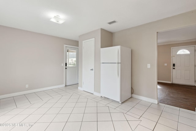 kitchen with white refrigerator and light tile patterned flooring