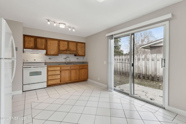 kitchen with tasteful backsplash, white appliances, sink, and light tile patterned floors