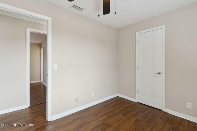 spare room featuring dark hardwood / wood-style flooring and ceiling fan