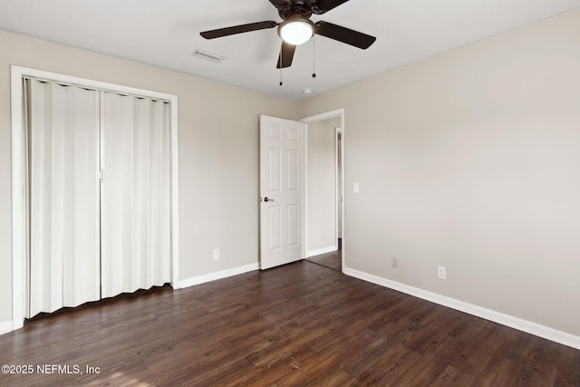 unfurnished bedroom featuring dark wood-type flooring, ceiling fan, and a closet