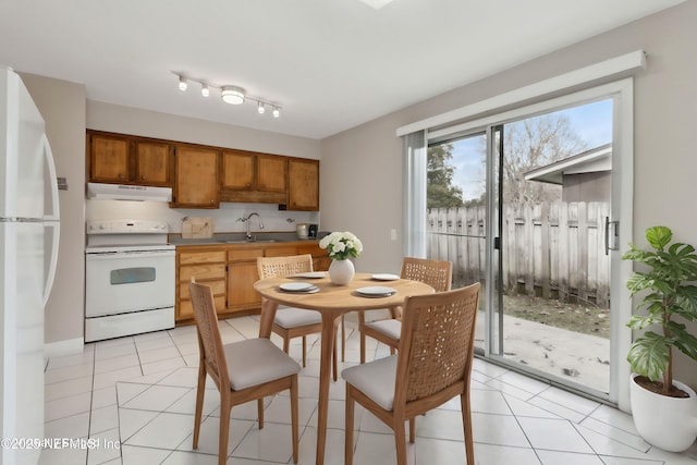 kitchen featuring white appliances, sink, decorative backsplash, and light tile patterned floors