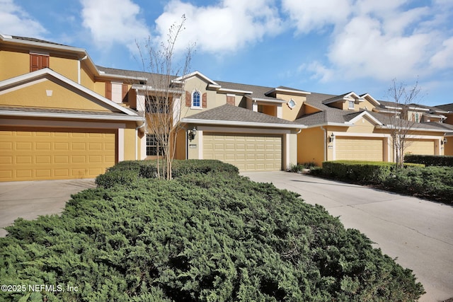 townhome / multi-family property featuring stucco siding, driveway, and a garage